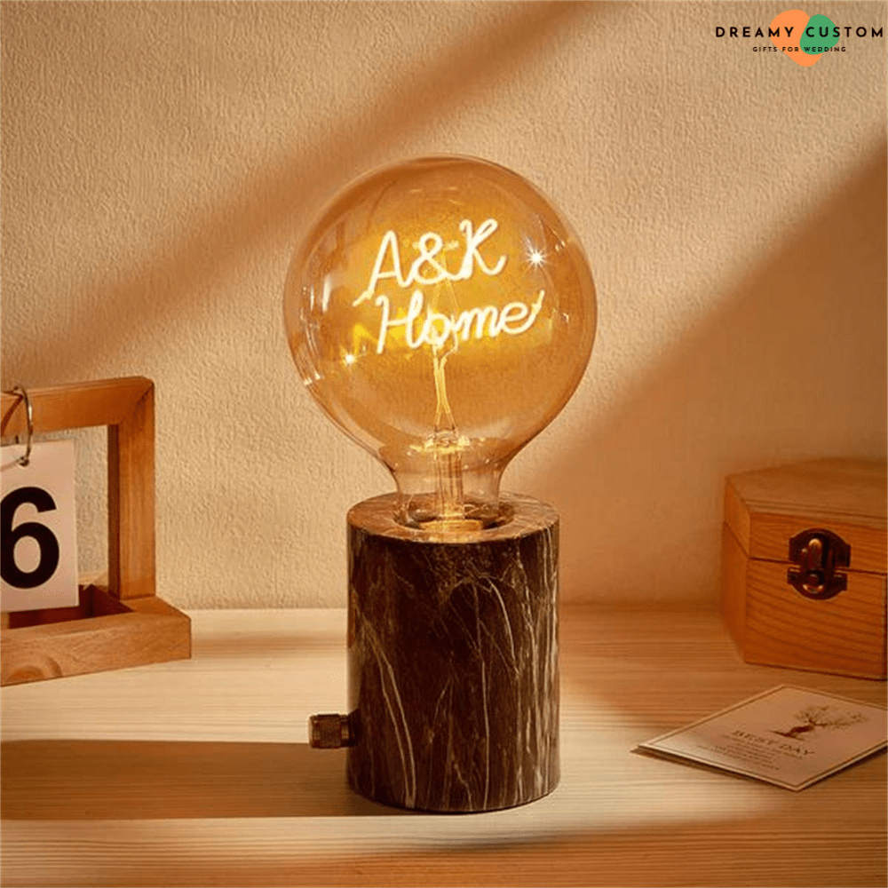 Una cálida y elegante bombilla de filamento personalizada con un mensaje luminoso único, montada en una base de mármol con estilo. Un regalo original y significativo para bodas o aniversarios.