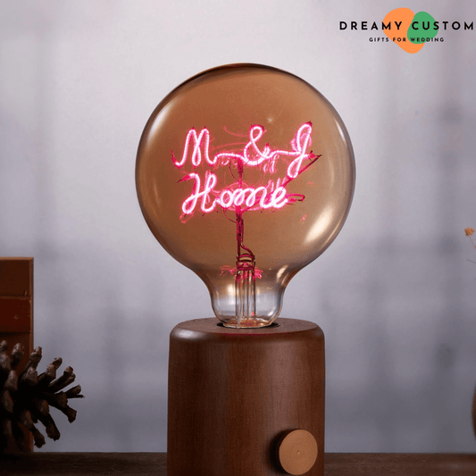 A stunning personalized filament light bulb with glowing custom text, elegantly placed on a wooden base. A unique and romantic gift, perfect for weddings, anniversaries, or home décor.