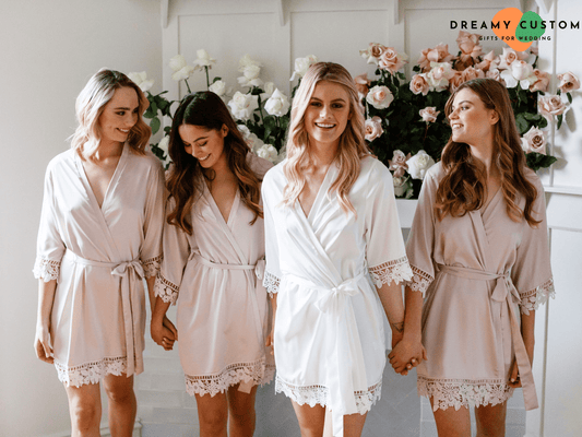 La novia y sus damas de honor lucen elegantes batas de satén con encaje, perfectas para los momentos previos a la boda. Un detalle personalizado que realza la experiencia nupcial con estilo y comodidad.