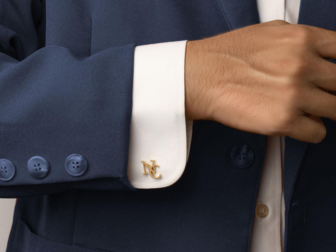 A close-up of personalized gold cufflinks with initials, perfectly complementing a groom's wedding attire. These cufflinks make for a timeless, elegant gift, adding a unique, customized touch to formal wear.