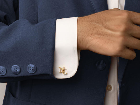 A close-up of personalized gold cufflinks with initials, perfectly complementing a groom's wedding attire. These cufflinks make for a timeless, elegant gift, adding a unique, customized touch to formal wear.