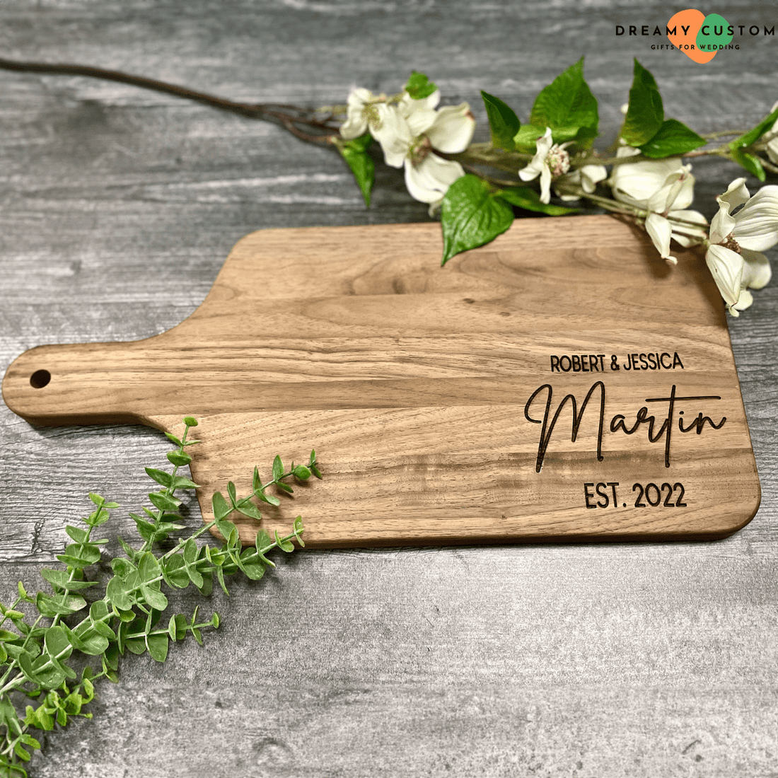 Personalized wooden cutting board engraved with "Robert & Jessica Martin, EST. 2022." A thoughtful wedding gift idea, combining elegance and practicality for couples