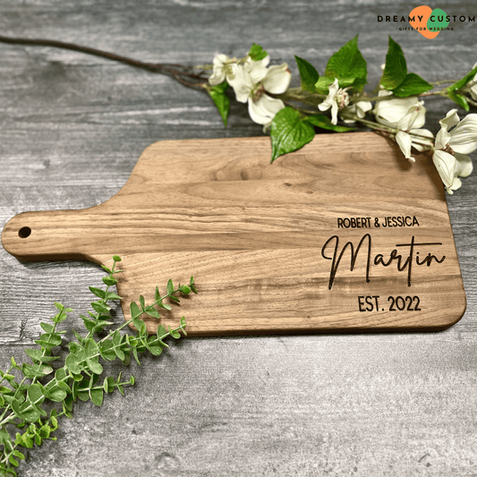 Personalized wooden cutting board engraved with "Robert & Jessica Martin, EST. 2022." A thoughtful wedding gift idea, combining elegance and practicality for couples