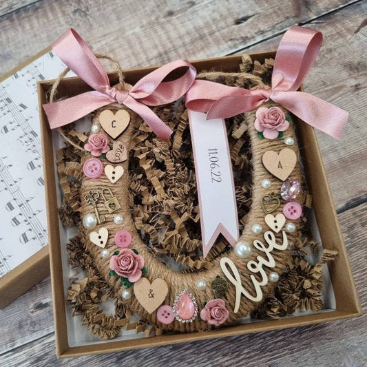 A handcrafted wedding horseshoe adorned with pearls, roses, charms, and a special date—symbolizing love, luck, and a beautiful beginning for the happy couple.
