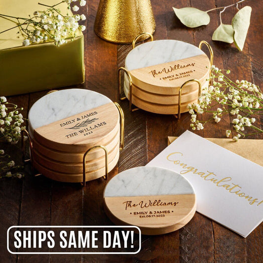 A set of personalized marble and wood coasters with "The Williams" and "Emily & James" engraved, perfect for weddings or housewarming gifts. Ships the same day, displayed alongside a congratulatory card.