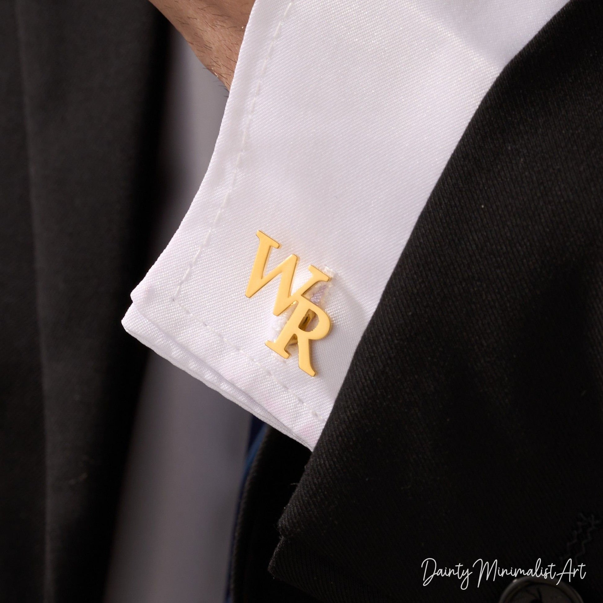 Gold "WR" initial cufflinks attached to a crisp white shirt cuff.