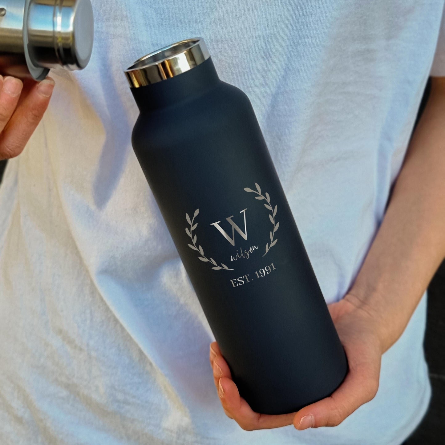 Personalized stainless steel water bottle with engraved "W" and "Wilson EST. 1991," ideal for custom gifts.