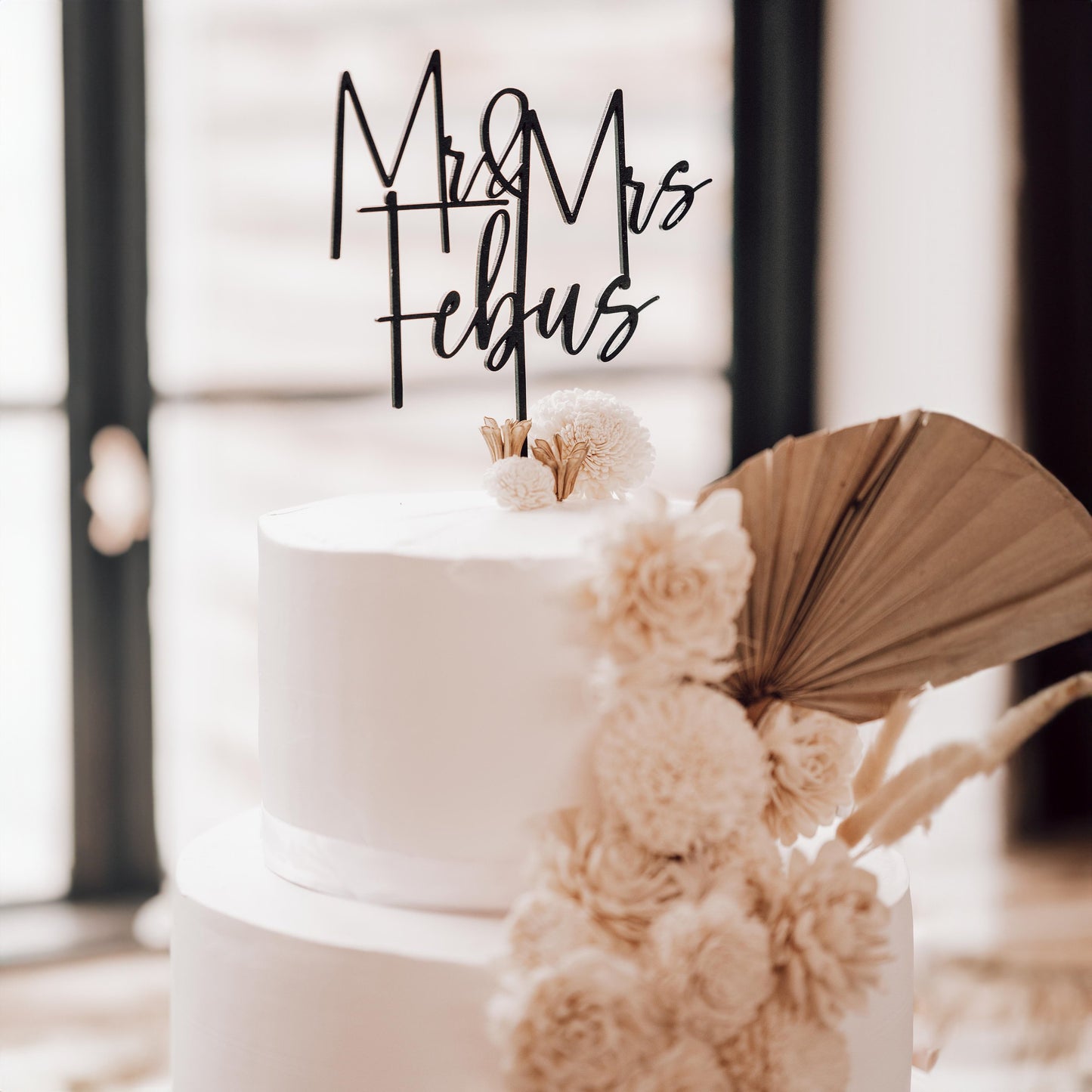 Gold cake topper with floral decorations for a romantic touch.