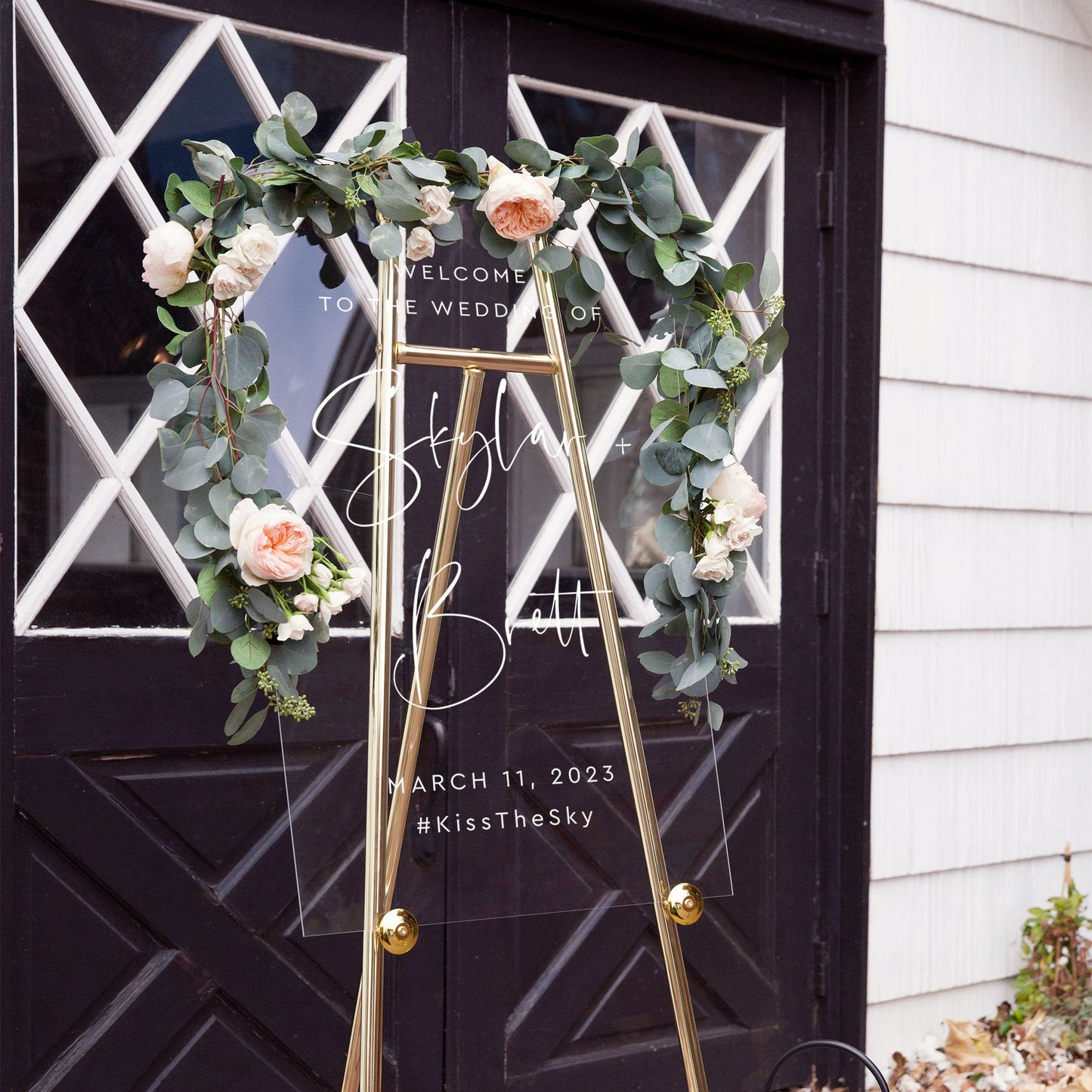 Floral-themed wedding welcome sign in a glass frame, personalized for Skylar and Brett.