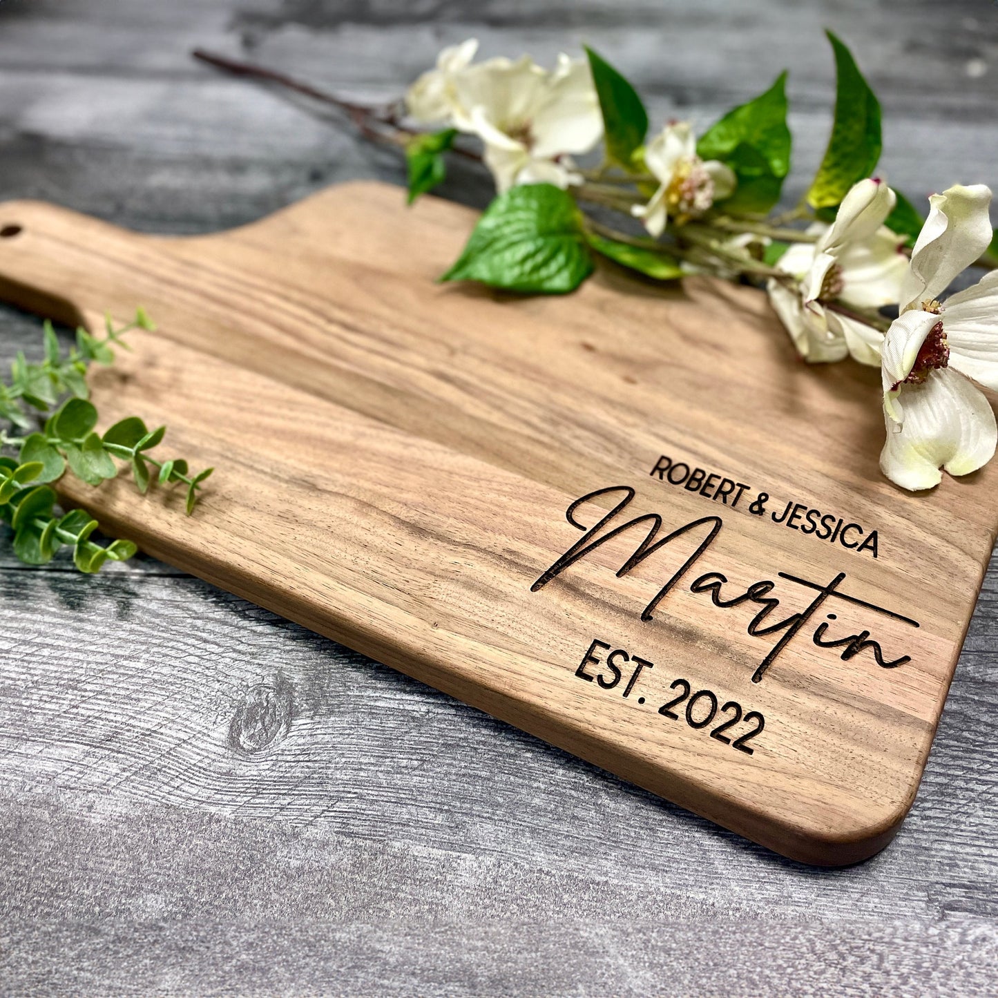 Personalized monogrammed charcuterie board made from high-quality walnut or red oak with custom engraving for wedding gifts and special occasions.