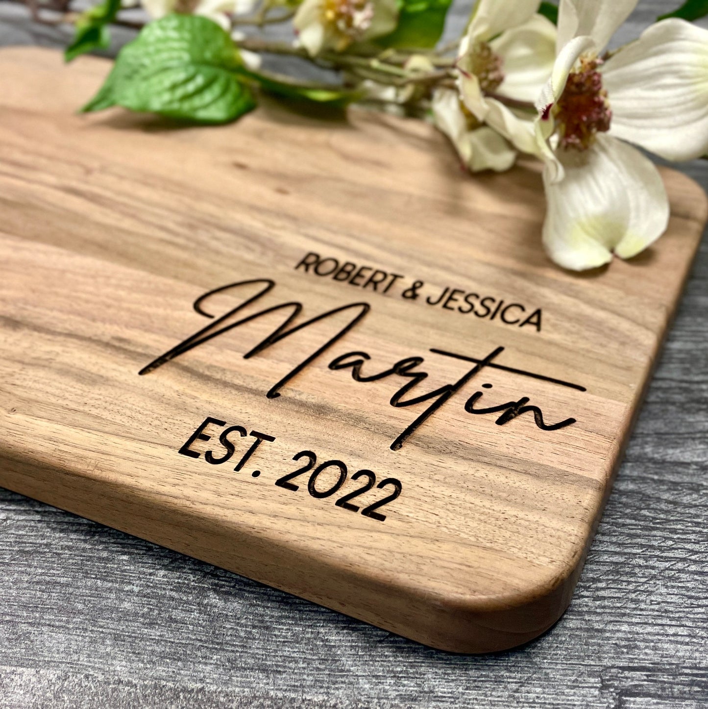 Close-up of custom engraved monogrammed charcuterie board with names and wedding date.