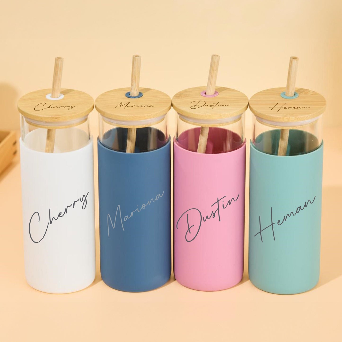 Glass tumblers with bamboo lids, customized with names.