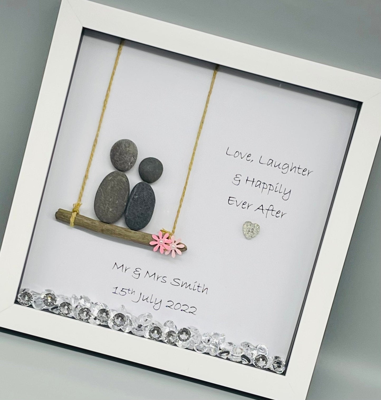 Wedding-themed pebble art picture in a white frame with hanging details