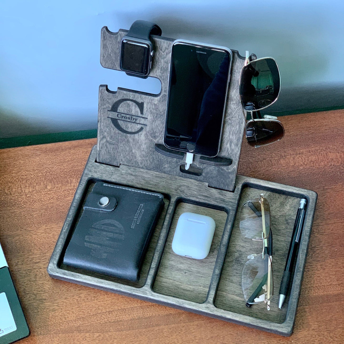 Wooden phone stand with compartments for glasses, wallet, AirPods, and keys.