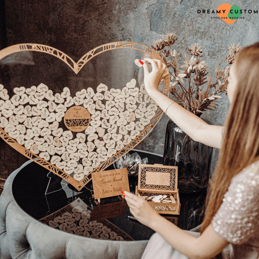 A heart-shaped wedding guest book with personalized wooden pieces where guests can leave their names and messages. A unique and special keepsake for the newlyweds to cherish forever.