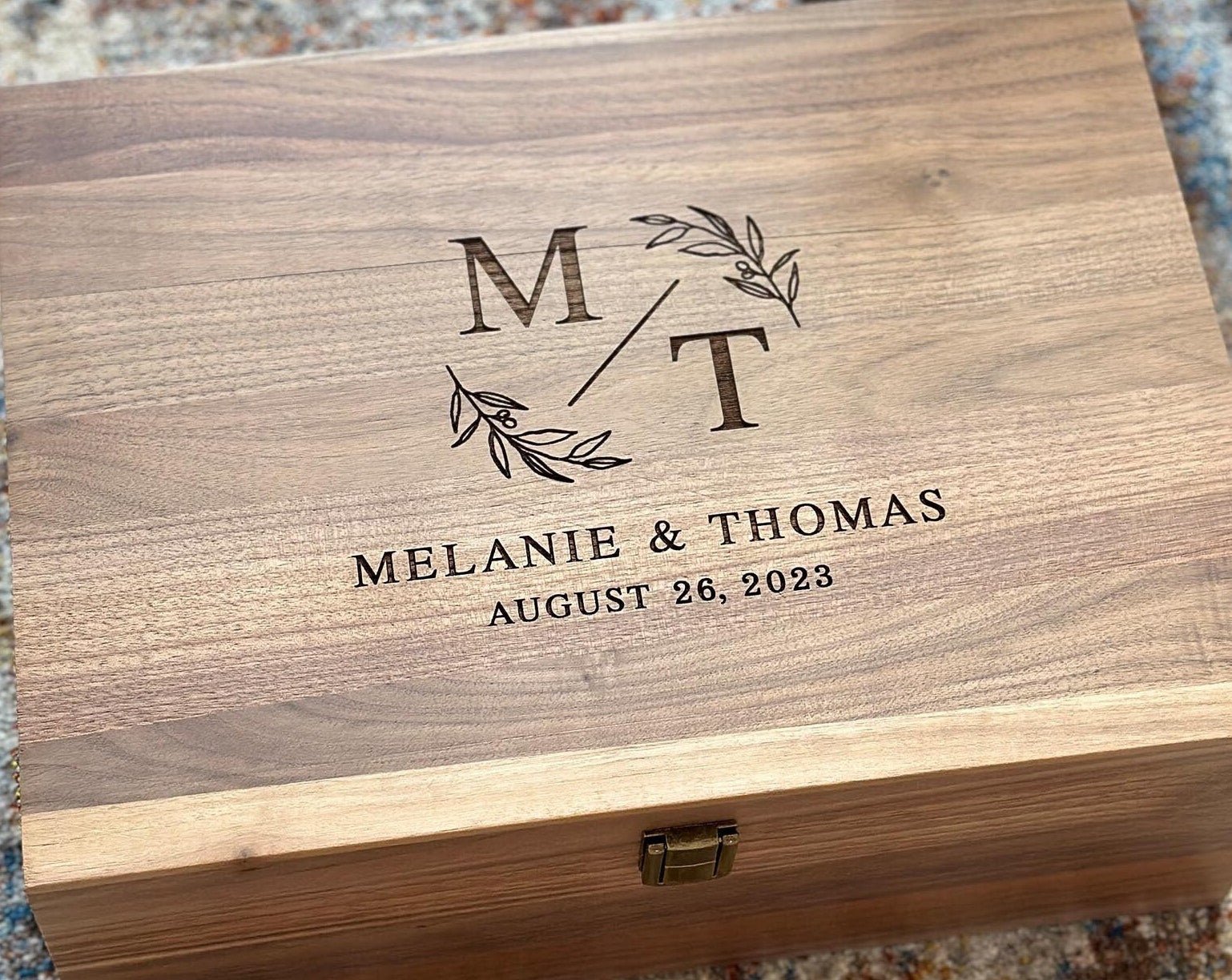 Custom engraved walnut keepsake box with monogram and leaf accents, personalized with names Melanie & Thomas and date.