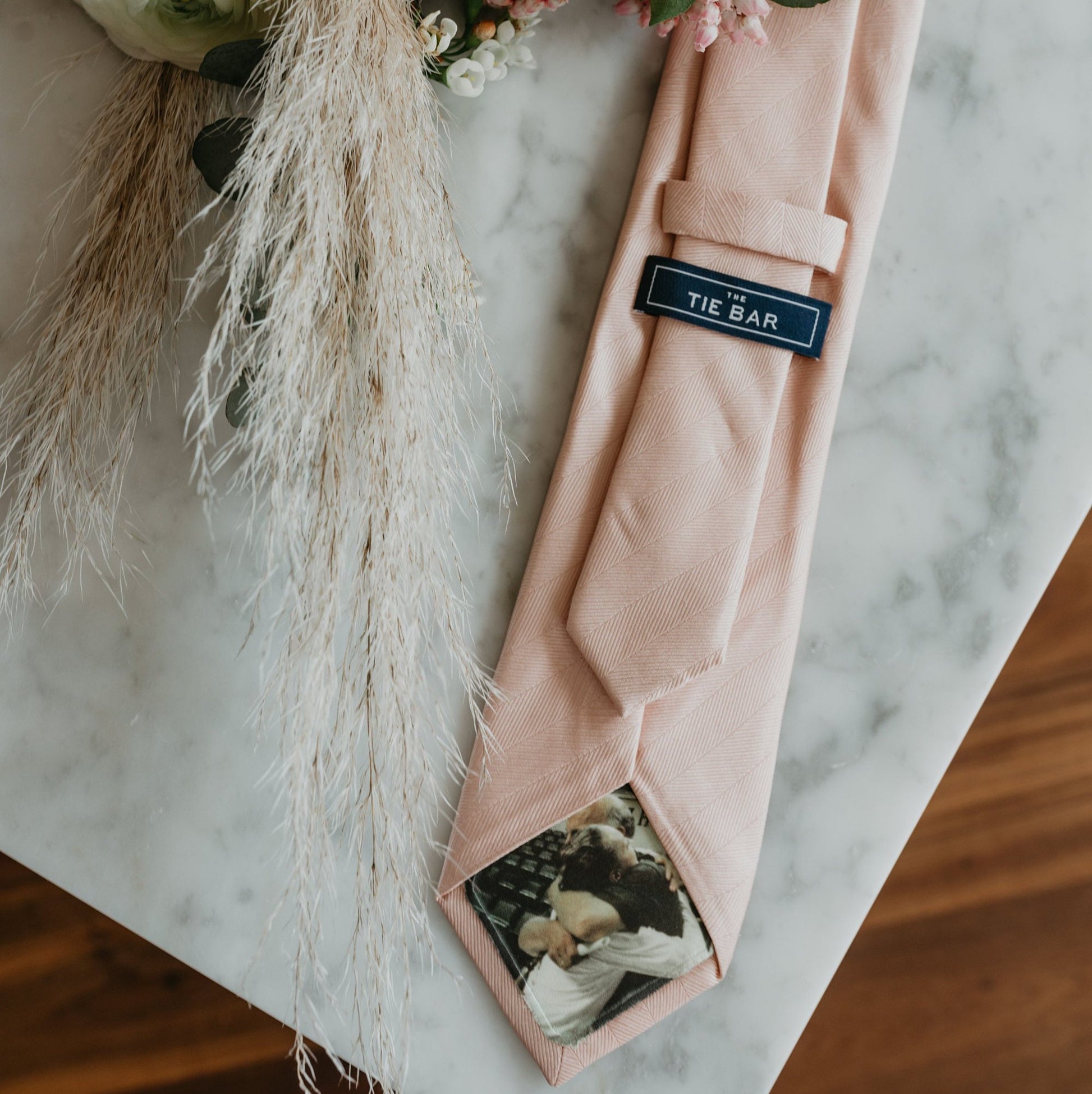 Light-pink-tie-with-a-custom-photo-tie-patch-featuring-a-heartwarming-photo-of-a-family.