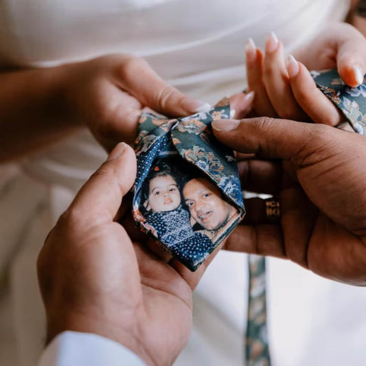 Bride holding groom's tie revealing a personalized photo patch featuring childhood memory