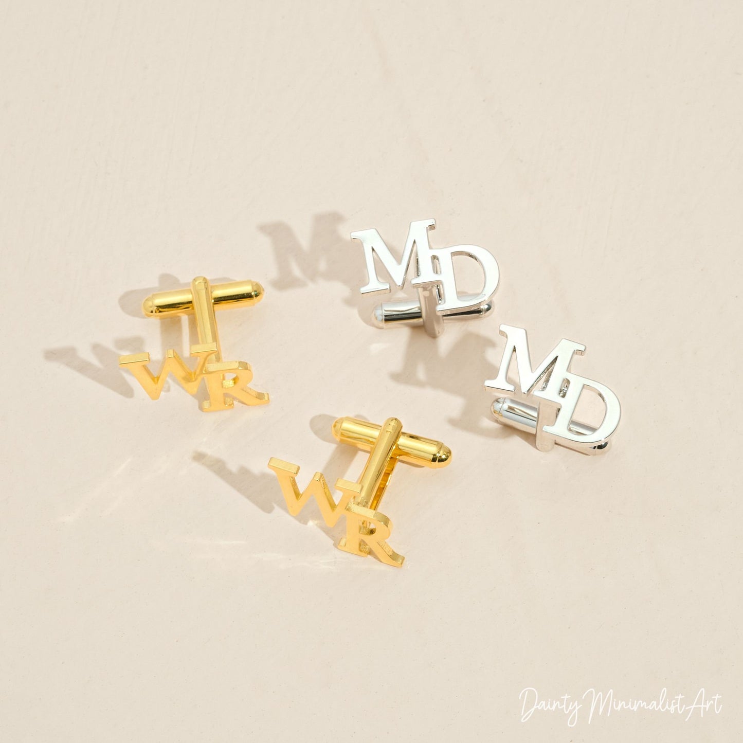 A set of personalized gold and silver initial cufflinks displaying the letters WR and MD, perfect for custom gifts and special events.