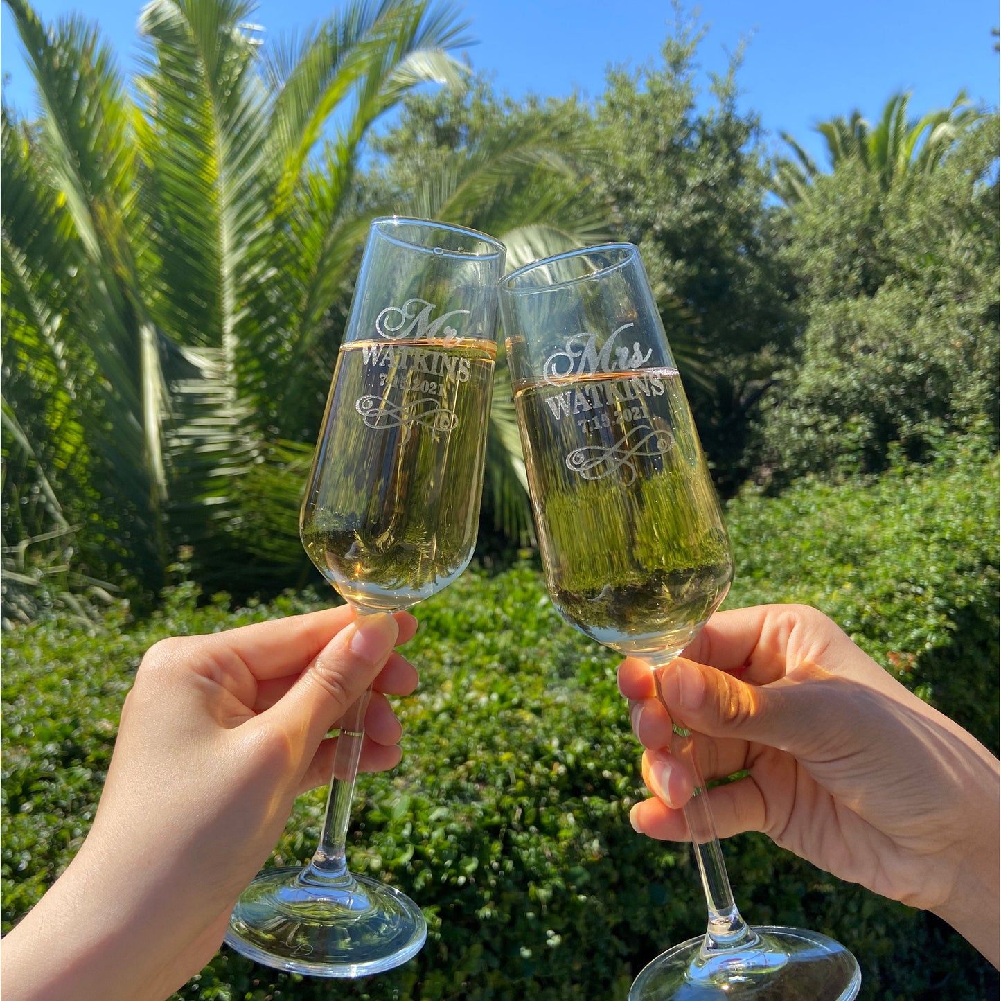 Couple toasting outdoors with personalized wedding champagne flutes