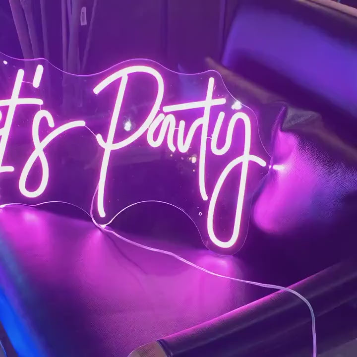 A short video showcasing vibrant custom neon wedding signs in various designs and colors. The footage features a glowing "Let's Party" sign in pink LED placed on a lounge chair, followed by a "You're like really pretty" sign in neon pink with a modern script font. Additional neon signs with different phrases and colors, such as blue and white LED, are displayed in the background, creating a stylish and celebratory ambiance for weddings and special events.