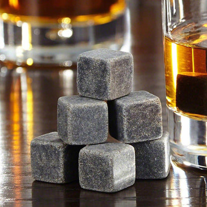 Set of premium whiskey stones placed beside engraved whiskey glasses, providing optimal chilling without dilution.