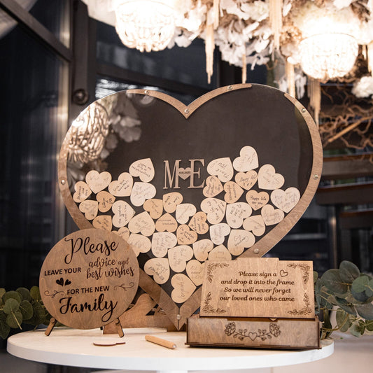 Large heart-shaped wooden guest book with engraved initials and handwritten guest messages on wooden hearts.