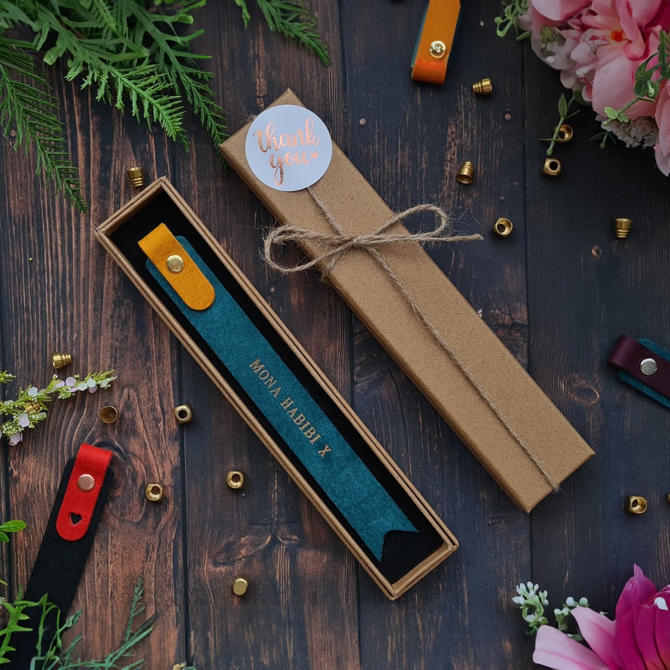 Blue leather bookmark with custom text, packaged in a stylish kraft box, perfect for gifting.