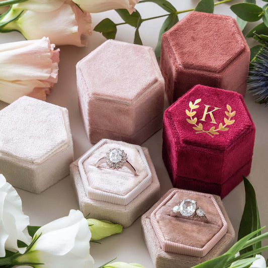 Red hexagon velvet ring box with gold foil initial 'K' for engagement or wedding.