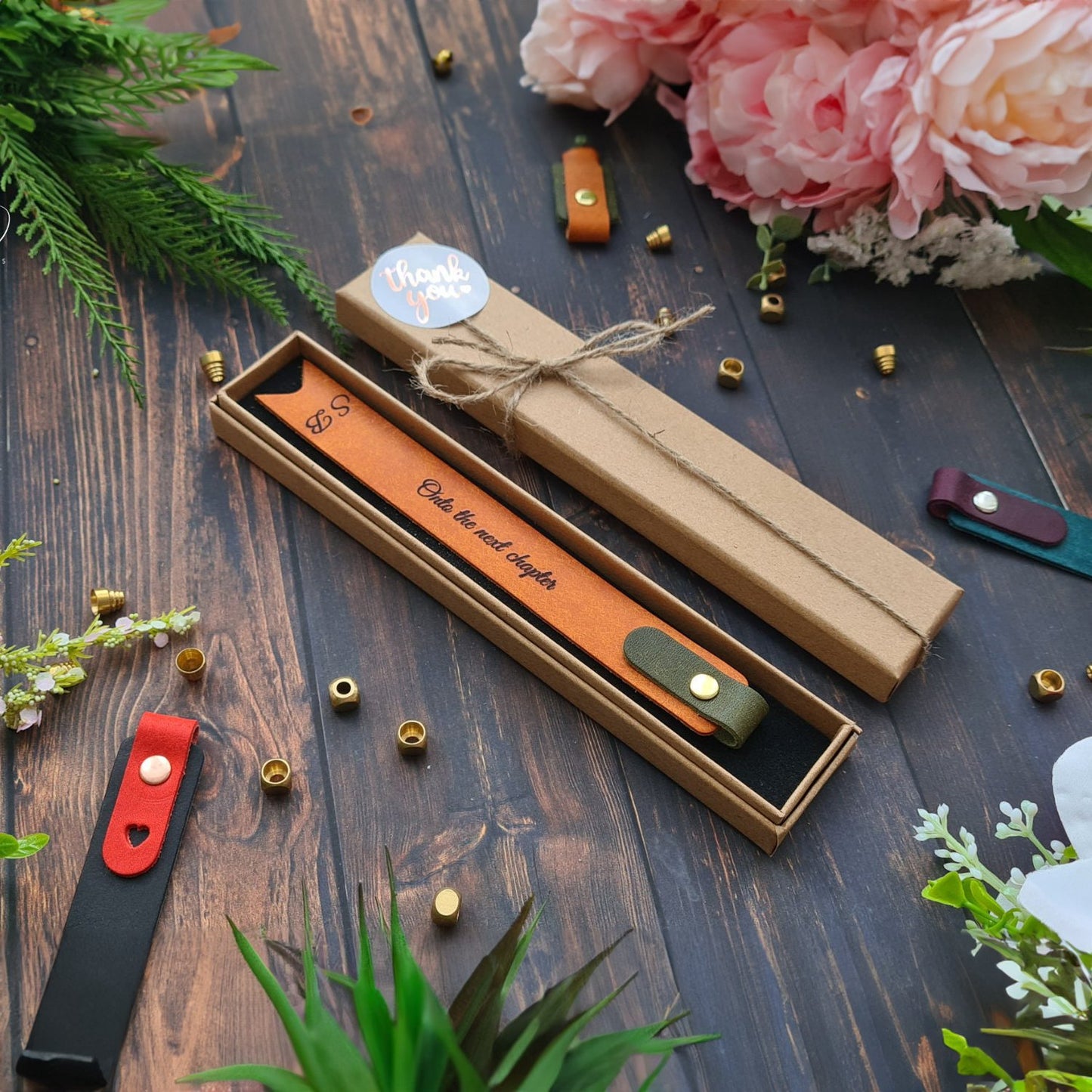 Set of vibrant leather bookmarks with custom names, packed neatly in a gift box.
