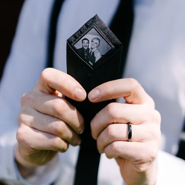 Custom Photo Tie Patch: A tie with a black and white photo patch held by two hands.