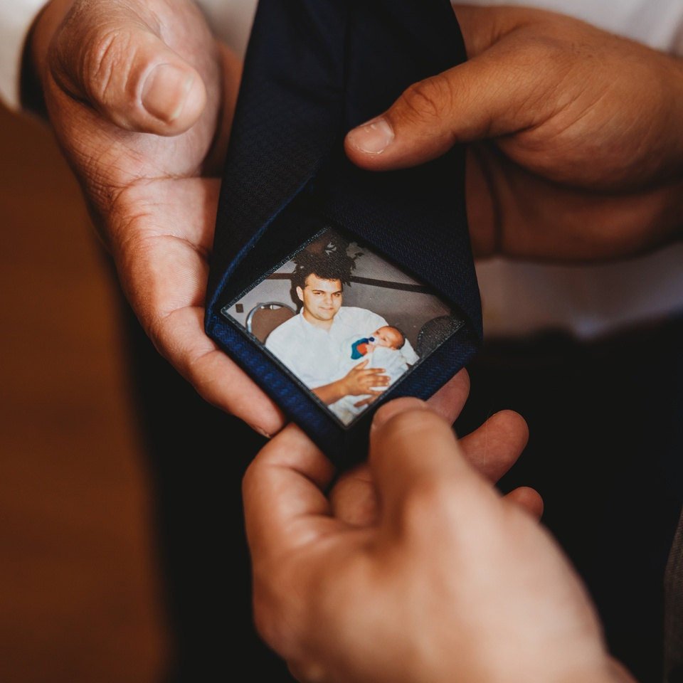 Custom Photo Tie Patch: A hand holding a tie with a patch of a father holding a baby.