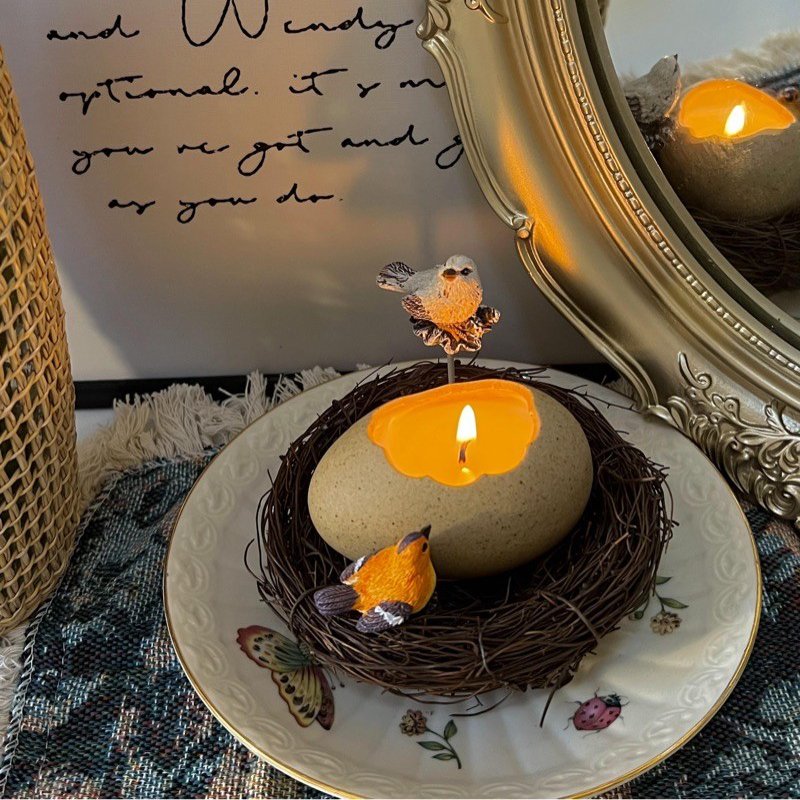 Kerze in Eierform mit Spottdrossel und Vogel
