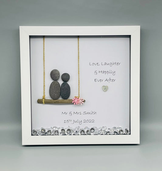Handmade pebble art picture in a white square frame with couple design