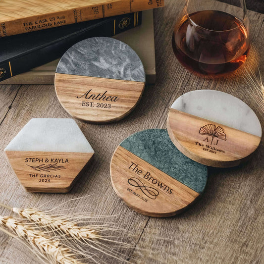 Set of personalized marble and wood coasters with engraved names and dates.