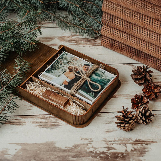 Rustic wooden wedding photo box with personalized engraving, including a tied photo bundle and decorative pinecones.